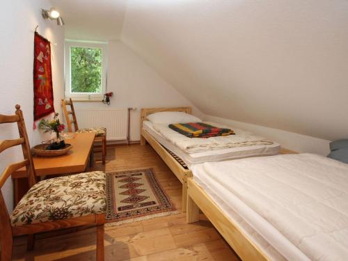 two beds in a room with a table and chairs at Holiday home Seeidyll, Teupitz in Teupitz