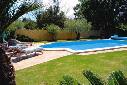 - une piscine dans une cour avec 2 chaises longues dans l'établissement Cozy Noves Home with Pool Access, à Noves