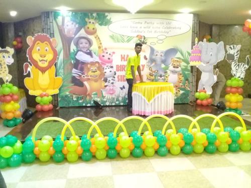 a boy standing in front of a stage with a lion party at Hyders Park The Business Hotel in Thanjāvūr