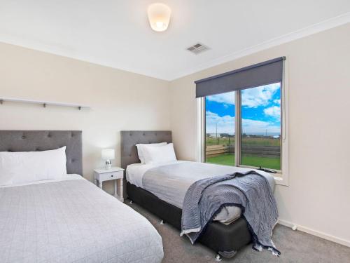 a bedroom with two beds and a large window at Ocean Mist in Port Fairy
