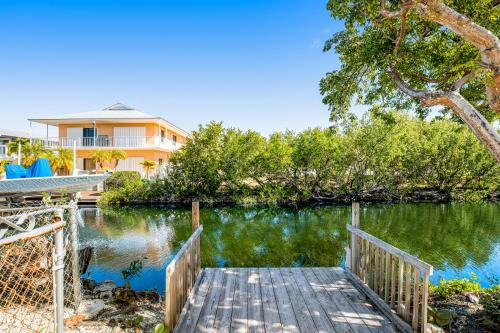 a house with a wooden bridge over a body of water at Tradewinds Treat in Big Pine Key