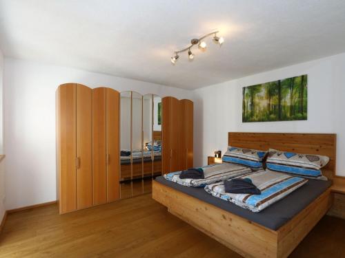 1 dormitorio con cama de madera y armario de madera en Holiday flat Schöser, Fügen, en Fügenberg