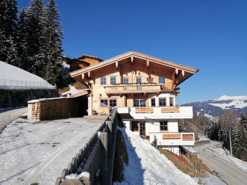 a house on a hill with snow on the ground at Apartment in Fügenberg near Spieljochbahn in Fügenberg