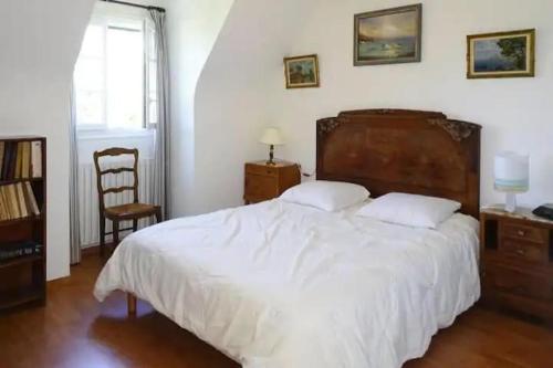 um quarto com uma grande cama branca e uma cadeira em Holiday home with private outdoor pool, Gouesnac"h em Gouesnach