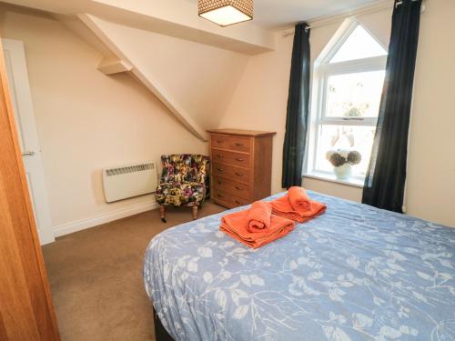 um quarto com uma cama, uma cadeira e uma janela em Carisbrooke House, Apartment 6 em Scarborough