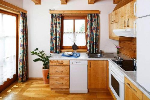 a kitchen with wooden cabinets and a window at Chalet near Kalkalpen National Park in Schlierbach