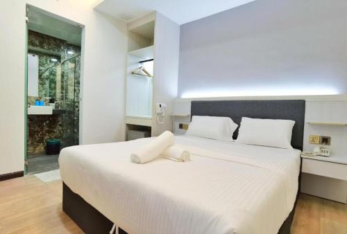 a bedroom with a large white bed with white pillows at BOOKME HOTEL in Johor Bahru