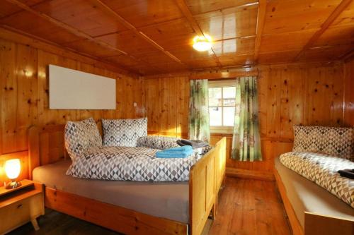 ein Schlafzimmer mit einem Bett in einer Holzhütte in der Unterkunft Apartments, Tobadill in Tobadill