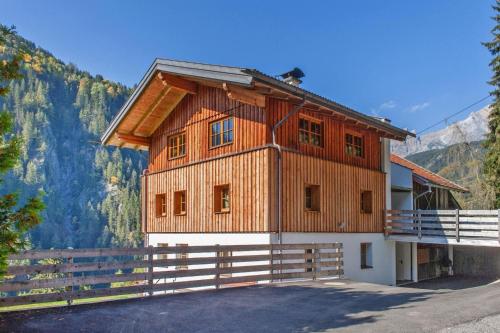 a wooden house in the mountains with a fence at Farmhouse in Tobadill with Mountain Views in Tobadill