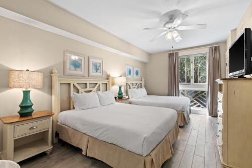 a bedroom with two beds and a flat screen tv at Salty Escape in Destin