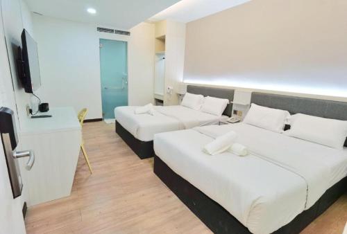 a hotel room with two beds and a flat screen tv at BOOKME HOTEL in Johor Bahru