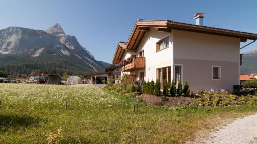a house in a field with mountains in the background at Chalet Melodie in Ehrwald