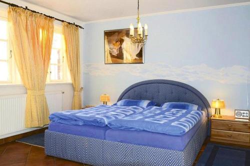 Un dormitorio con una cama azul y una lámpara de araña. en Holiday flat Oevenum - DNS10102e-P, en Oevenum