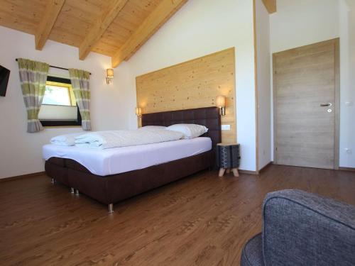 a bedroom with a large bed and wooden floors at Chalet Gamsknogel mit privatem Pool und Whirlpool in Inzell