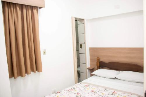 um quarto com uma cama e uma janela em Hotel Morada do Mar no Guarujá