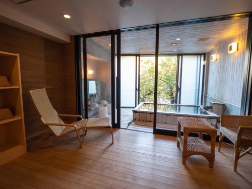 a living room with a tub and a table and chairs at Matsunoi in Minakami