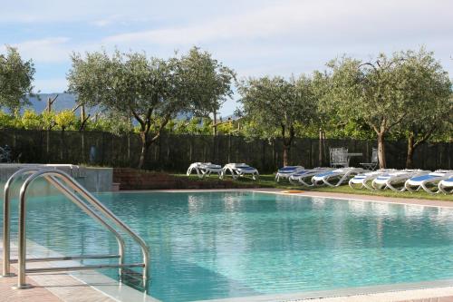 a swimming pool with lounge chairs and a resort at Residence Ulivi in Cavaion Veronese