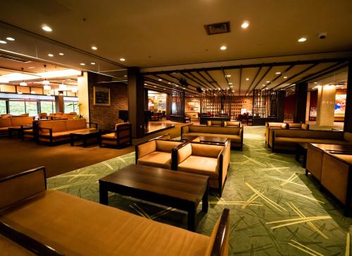 a lobby with couches and tables in a building at Matsunoi in Minakami