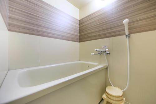 a bathroom with a bath tub and a toilet at Matsunoi in Minakami