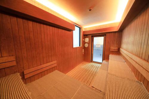 a empty room with wood paneled walls and a window at Matsunoi in Minakami