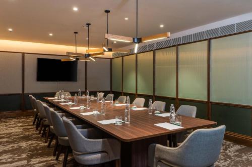 a conference room with a long table and chairs at Gardina Asoke Hotel & Residence in Bangkok
