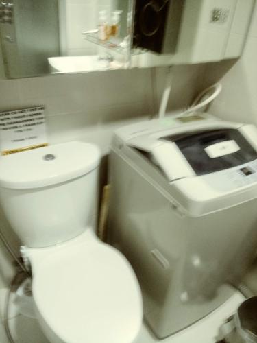 a bathroom with a white toilet and a sink at MOA Rental in Manila