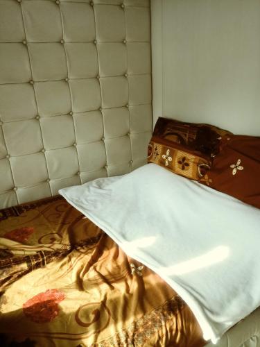 a bed with a white blanket and a suitcase on it at MOA Rental in Manila