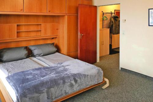 1 dormitorio con 1 cama con cabecero de madera en Apartment, Cuxhaven, en Döse