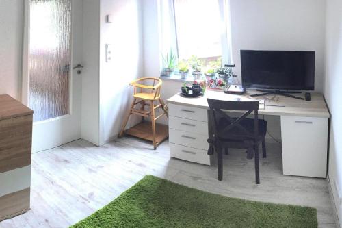 a room with a desk with a computer and a green rug at Ferienwohnung, Tambach-Dietharz in Tambach-Dietharz