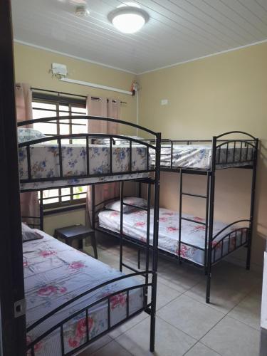 a room with three bunk beds in a room at Tu casa Menus de Boquete te espera in Alto Boquete