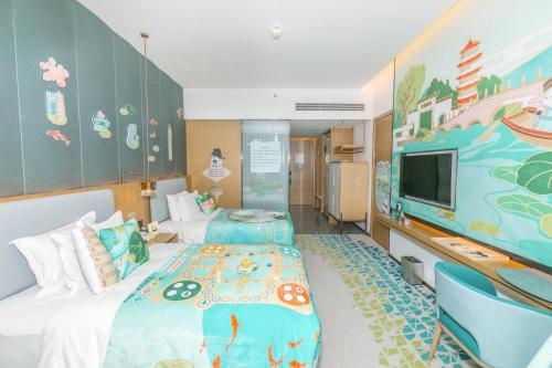 a bedroom with two beds and a tv in it at Holiday Inn Fuyang by IHG in Fuyang