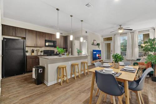 a kitchen and living room with a table and chairs at New! King Bed Trendy 1 BR Resort Style w/ Pool in Houston