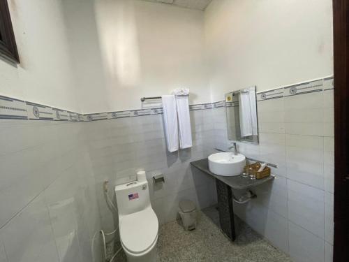 a white bathroom with a toilet and a sink at Đắk G'lung Bungalow in Bu Yal (1)