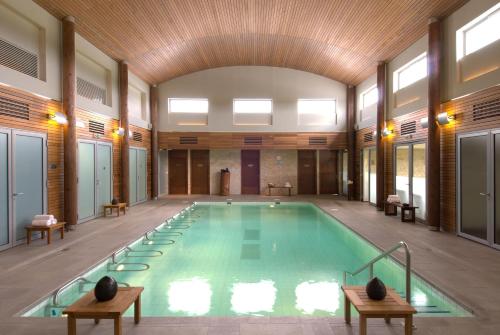 a pool in a large room with a wooden ceiling at Relais de Margaux - Hôtel & Spa in Margaux