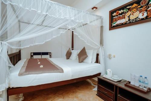 a bedroom with a bed with a canopy at Blue Sky Beach Resort in Unawatuna