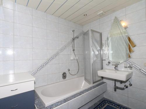 ein Bad mit einer Badewanne, einem Waschbecken und einer Dusche in der Unterkunft Apartment in Mayrhofen in the mountains in Mayrhofen