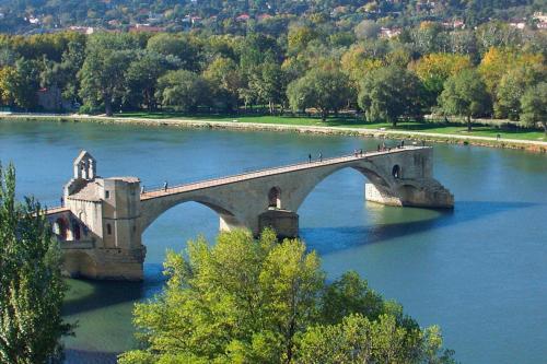 a bridge over a river with people walking on it at Apartment in Caderousse with Pool in Caderousse