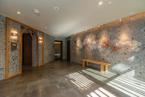a room with a bench and a wall with lights at Gardina Asoke Hotel & Residence in Bangkok