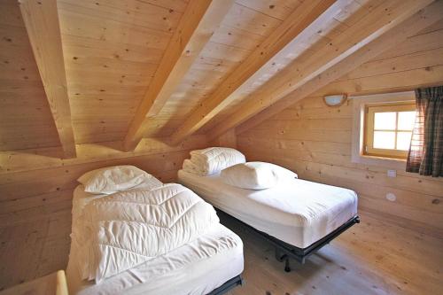 two beds in a room in a log cabin at Chalet, Königsleiten in Königsleiten