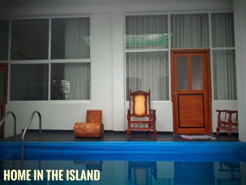 una casa en la isla con sillas y una puerta en Home in the Island, en Tangalle
