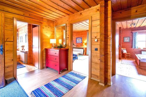 drewniany pokój z czerwoną komodą i sypialnią w obiekcie Chalets in Eben im Pongau w mieście Eben im Pongau