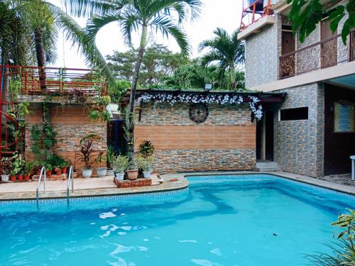 a swimming pool in front of a building at Villa Asuncion Country Inn and Resort Iloilo by RedDoorz in Iloilo City