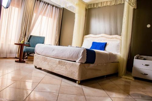 a bedroom with a large bed with a canopy at Lishi Resort Hotel in Kampala