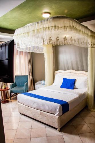 a bedroom with a large bed with a canopy at Lishi Resort Hotel in Kampala