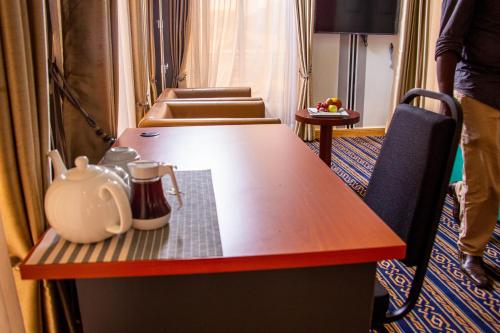 a table with a tea pot on top of it at Lishi Resort Hotel in Kampala