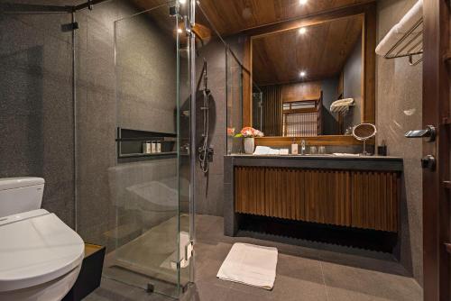 a bathroom with a shower and a sink and a toilet at Onsen at Moncham in Mae Rim
