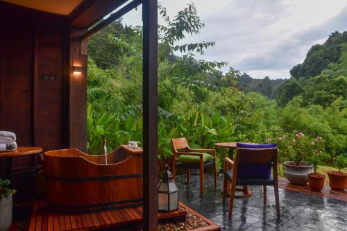 a room with a balcony with a table and chairs at Onsen at Moncham in Mae Rim