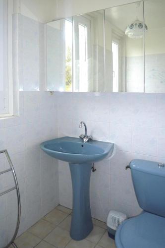 une salle de bain avec un lavabo bleu et des toilettes dans l'établissement Holiday Home Trebeurden by Pink Granite Coast, à Trébeurden