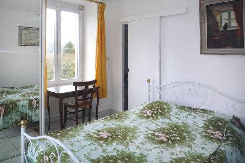 a bedroom with a bed and a table and a window at Holiday Home Trebeurden by Pink Granite Coast in Trébeurden