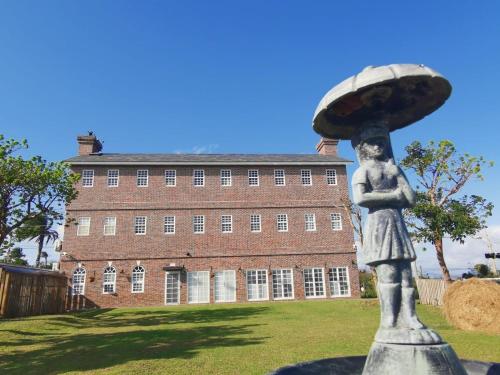 a statue in front of a large brick building at 墾丁勿忘我城堡莊園 in Hengchun
